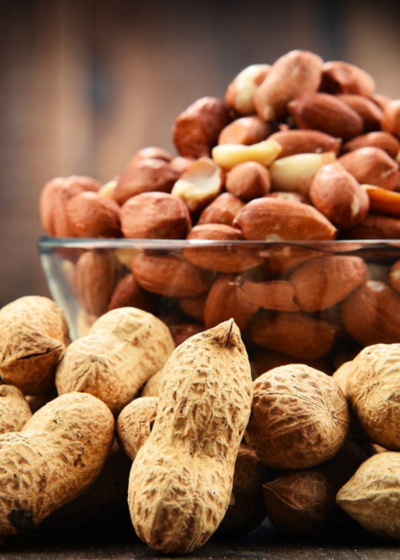 Bowl with peanuts on wooden table. Delicacies