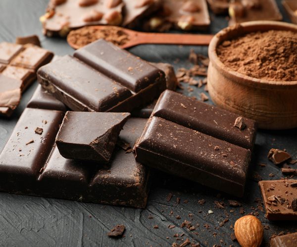 Chocolate, melted chocolate and almond on black background
