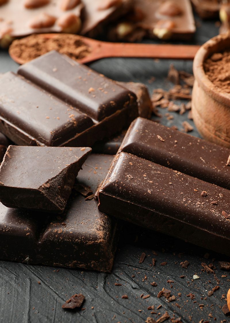 Chocolate, melted chocolate and almond on black background