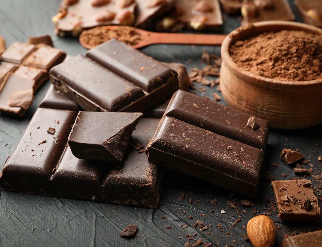 Chocolate, melted chocolate and almond on black background