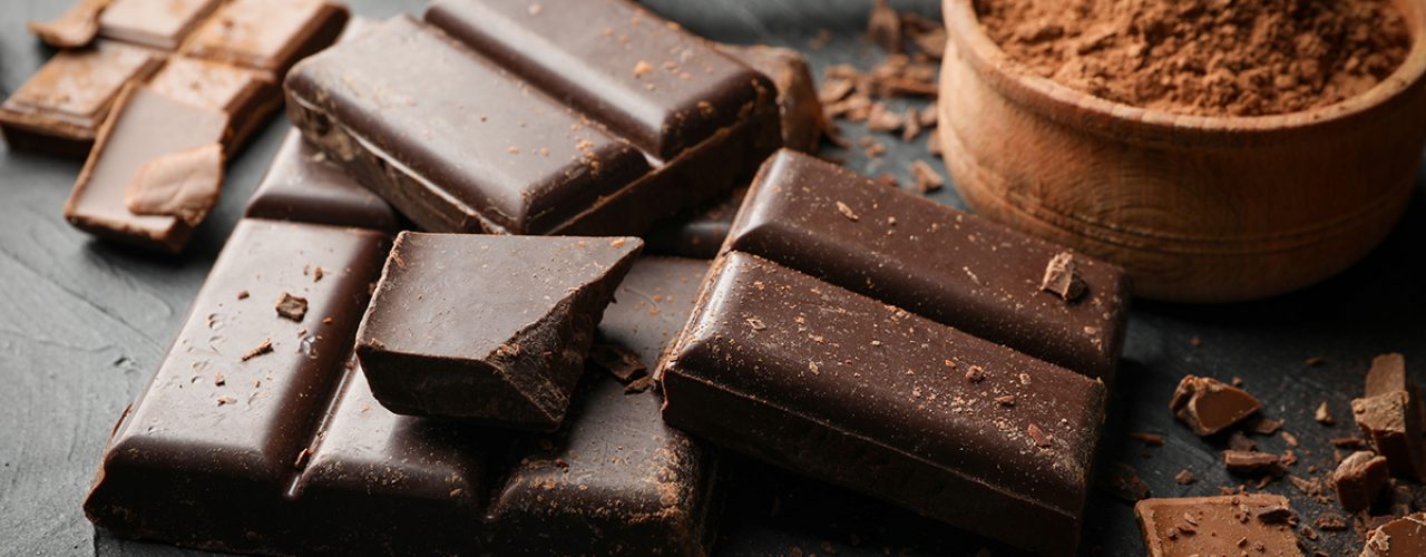 Chocolate, melted chocolate and almond on black background