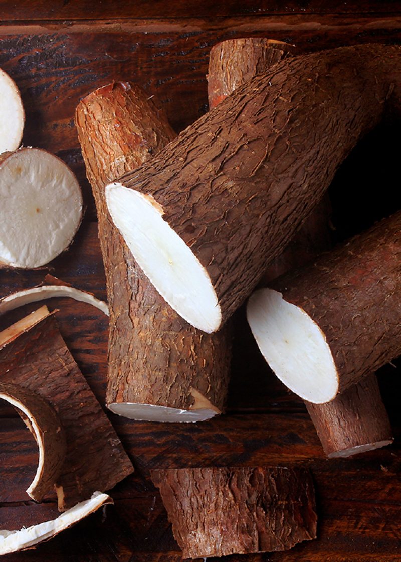 fresh cassava and peels and slices on rustic wooden table. Top view