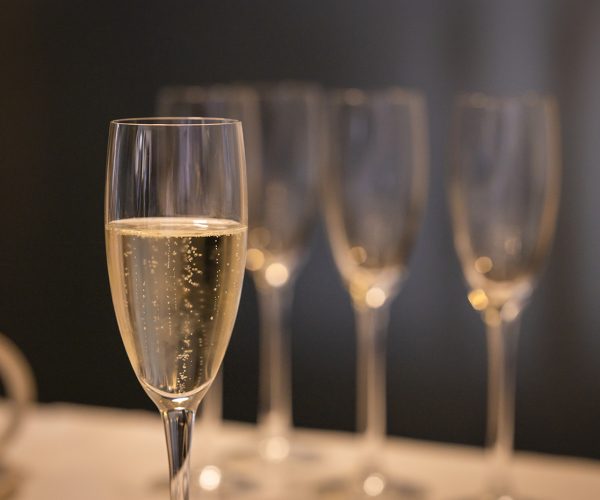Close-up with glass of champagne and blurred background with other glasses.